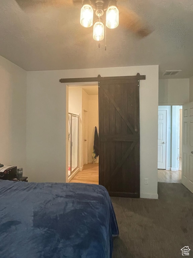 carpeted bedroom with visible vents and a barn door