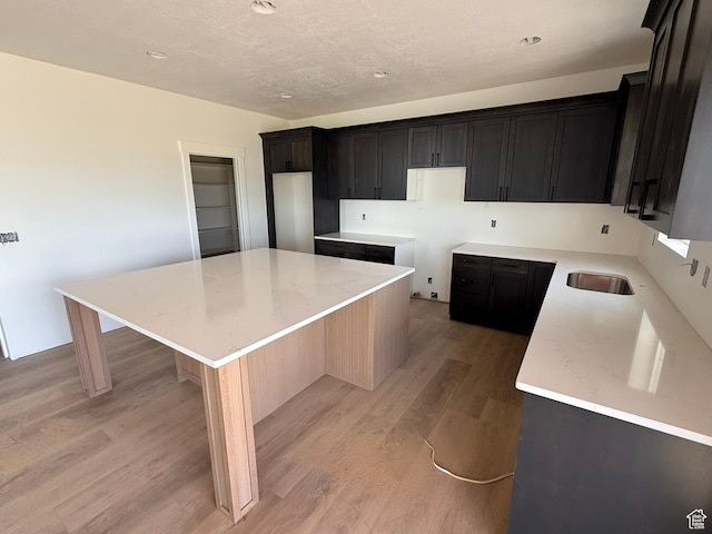 2405 W 3200 N, Farr West, UT 84404 - kitchen with light wood-style flooring, a kitchen island, a textured ceiling, and recessed lighting