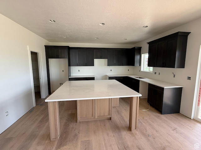 2405 W 3200 N, Farr West, UT 84404 - kitchen with a kitchen island, light wood finished floors, a textured ceiling, recessed lighting, and dark cabinets
