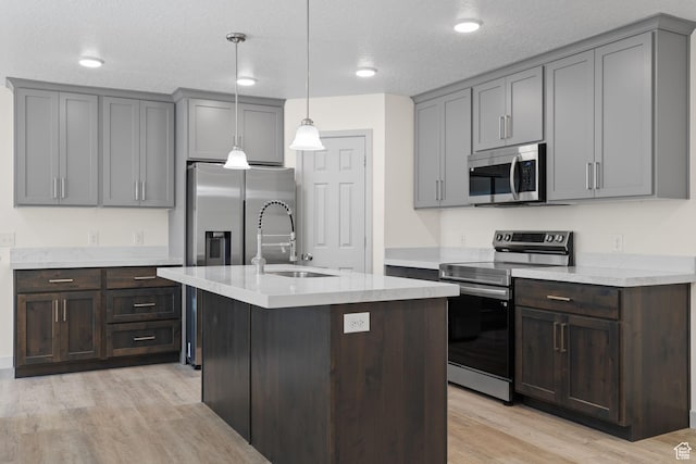 1614 N 160 E Unit 2, Orem, UT 84057 - kitchen featuring light wood-style flooring, a sink, light countertops, stainless steel appliances, and decorative light fixtures