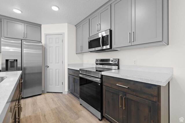 1614 N 160 E Unit 2, Orem, UT 84057 - kitchen featuring light wood-style flooring, a textured ceiling, recessed lighting, light countertops, and stainless steel appliances