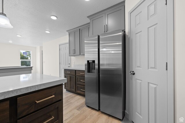 1614 N 160 E Unit 2, Orem, UT 84057 - kitchen with stainless steel fridge with ice dispenser, a textured ceiling, light wood finished floors, recessed lighting, and light stone counters