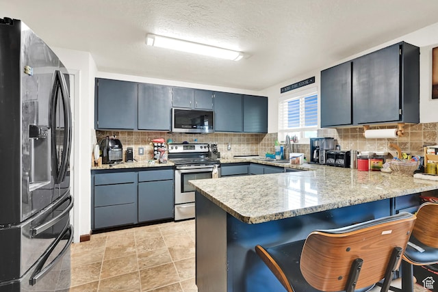 1705 W 4575 S, Roy, UT 84067 - kitchen featuring stainless steel appliances, a peninsula, tasteful backsplash, a kitchen breakfast bar, and a textured ceiling