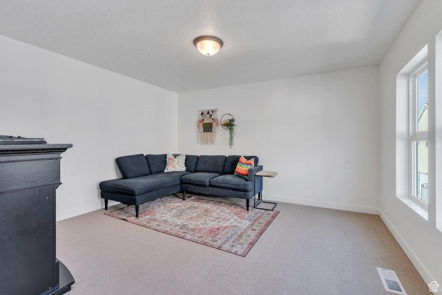 living area with carpet, visible vents, and baseboards