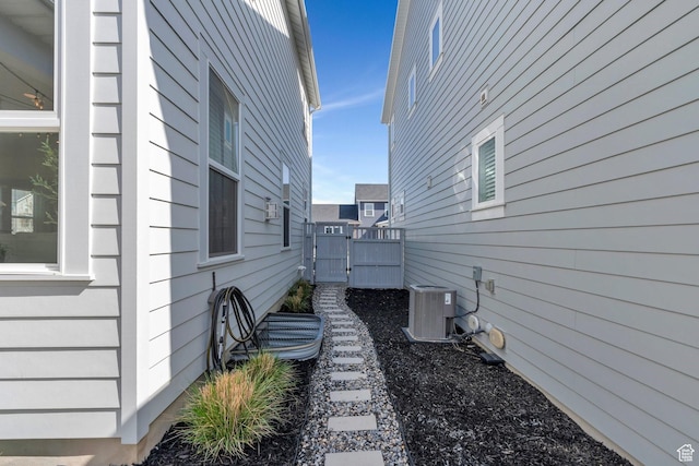 view of side of property featuring cooling unit and a gate