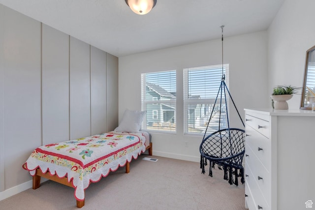 bedroom featuring visible vents, baseboards, and light carpet