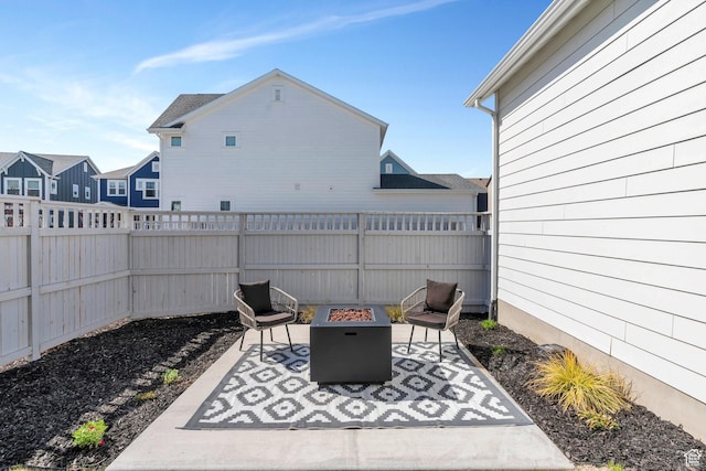 view of patio with an outdoor fire pit, a fenced backyard, and a residential view