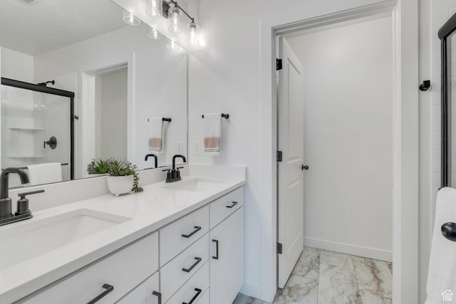 full bath featuring a sink, baseboards, marble finish floor, and a stall shower