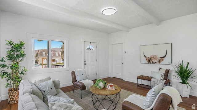 living room with baseboards, beam ceiling, and wood finished floors