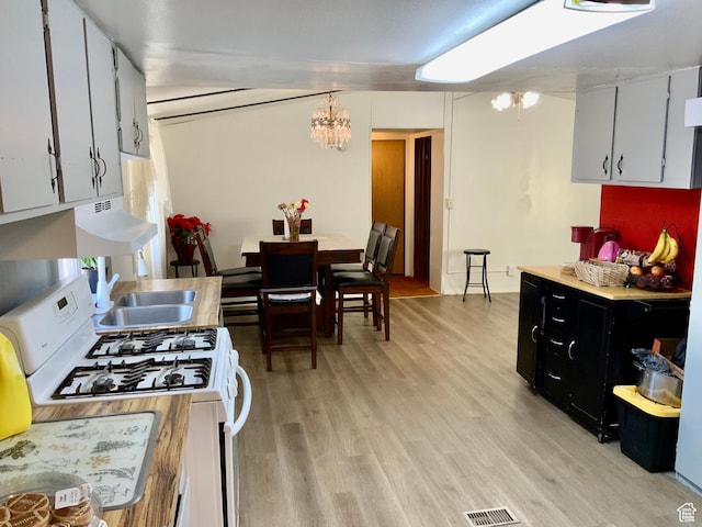 162 S Center St, Elsinore, UT 84724 - kitchen featuring white gas stove, light wood-type flooring, a sink, and a chandelier