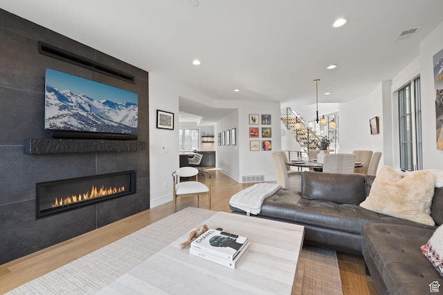 living area featuring recessed lighting, visible vents, a large fireplace, and wood finished floors