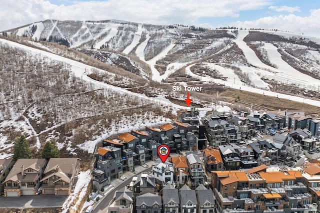 snowy aerial view featuring a residential view and a mountain view