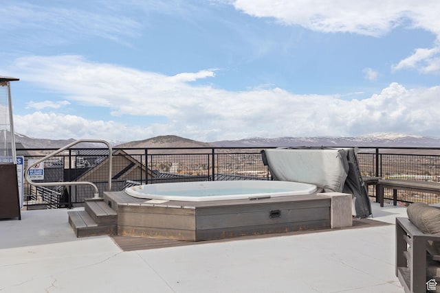 view of patio featuring a covered hot tub and a mountain view