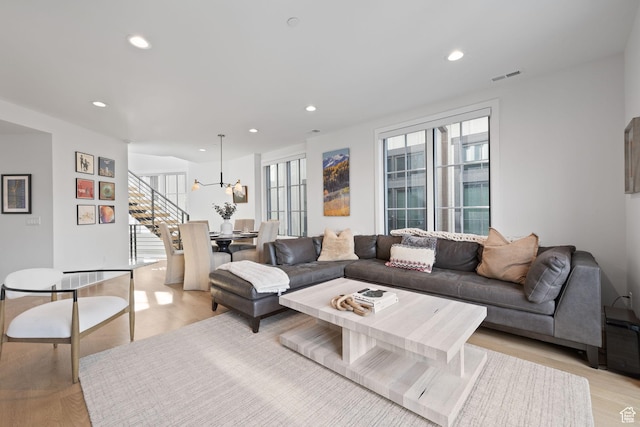 living area with visible vents, light wood-style flooring, recessed lighting, and stairway