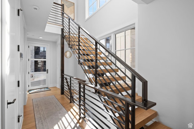 stairs with recessed lighting, baseboards, and wood finished floors