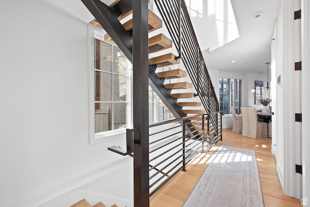 stairway with recessed lighting, baseboards, and wood finished floors