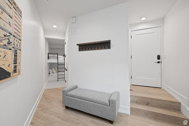 hall with recessed lighting, light wood finished floors, and baseboards