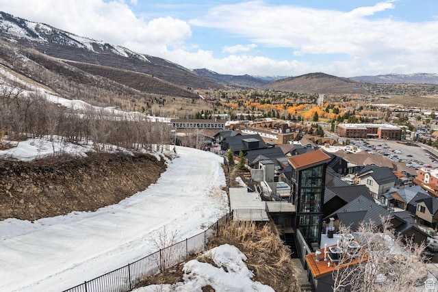 snowy aerial view with a mountain view and a residential view