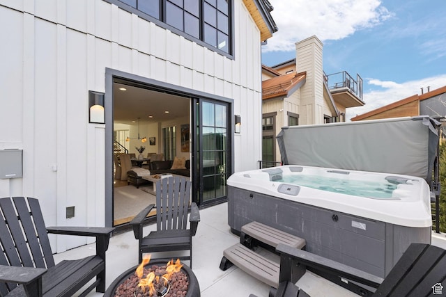 view of patio / terrace with an outdoor fire pit and a hot tub