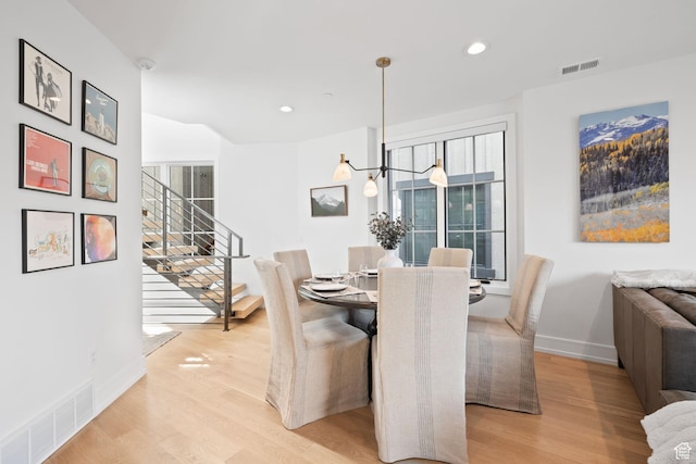 dining space featuring visible vents, light wood-type flooring, and a healthy amount of sunlight