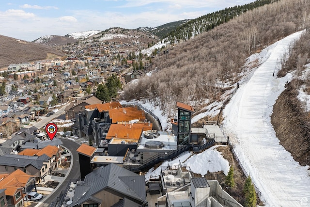 snowy aerial view with a residential view and a mountain view