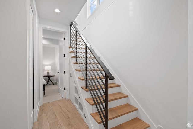 stairway with recessed lighting and wood finished floors