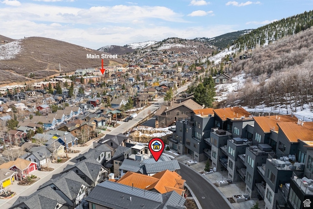 snowy aerial view featuring a mountain view and a residential view