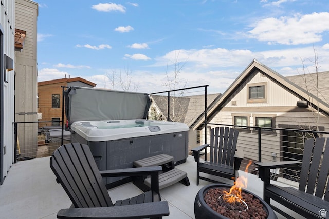 view of patio / terrace with a fire pit and a hot tub
