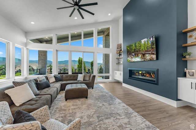 3131 E Lindsay Spring Rd, Heber City, UT 84032 - living area with ceiling fan, a glass covered fireplace, recessed lighting, wood finished floors, and baseboards