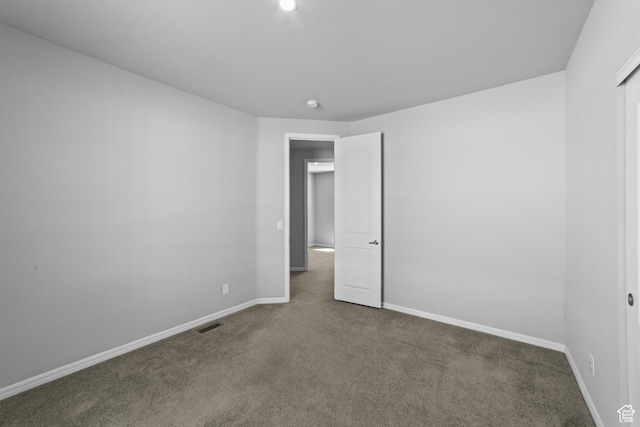 unfurnished bedroom featuring carpet floors, baseboards, and visible vents