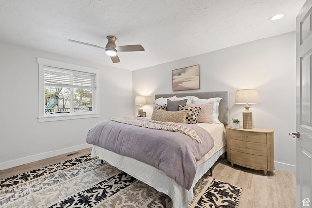 bedroom with baseboards, light wood finished floors, ceiling fan, and recessed lighting