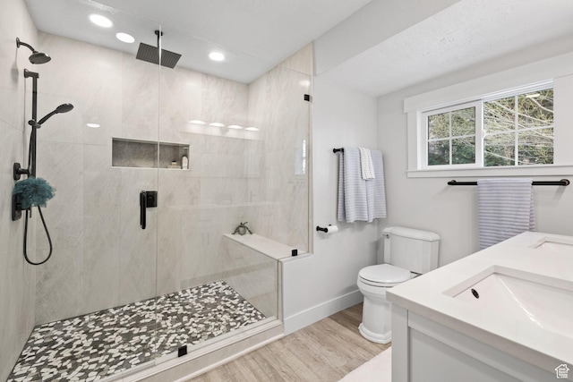 full bathroom featuring toilet, a shower stall, and wood finished floors