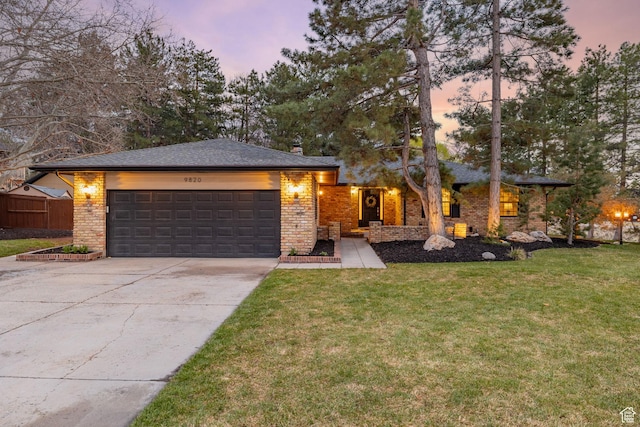 view of front facade featuring a chimney, driveway, a garage, fence, and a lawn
