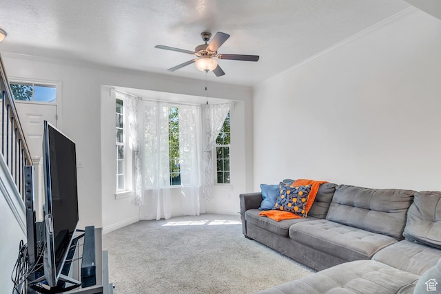 carpeted living room featuring crown molding, ceiling fan, baseboards, and stairway