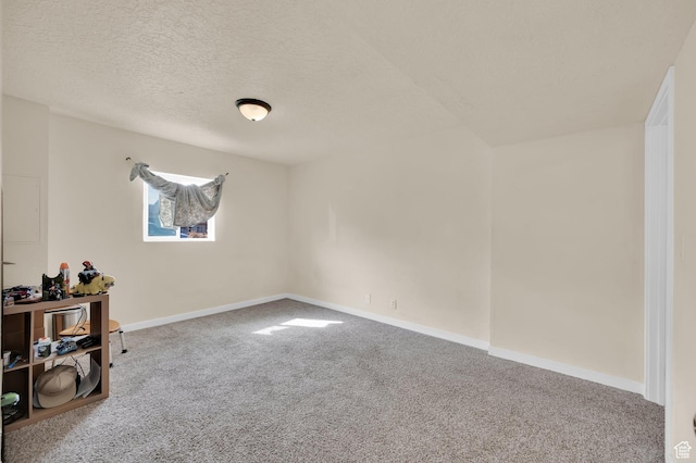 spare room featuring a textured ceiling, baseboards, and carpet