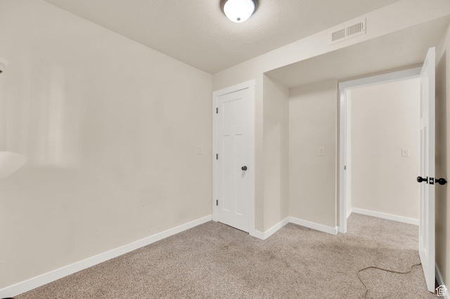 spare room featuring visible vents, baseboards, and carpet flooring