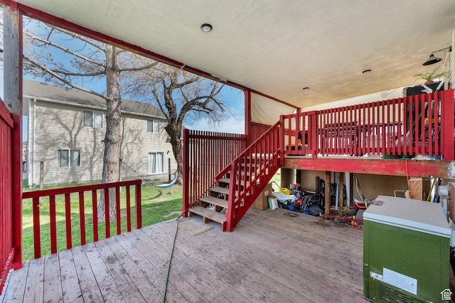 deck featuring stairs and a lawn