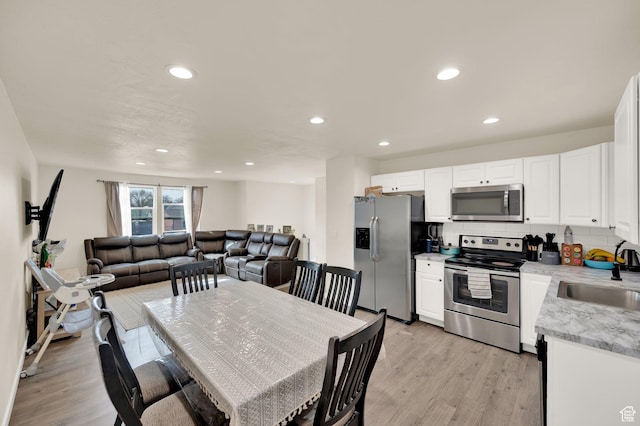 dining space featuring light wood finished floors and recessed lighting