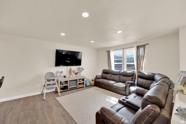 living room featuring baseboards, recessed lighting, and wood finished floors