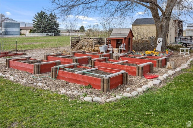 view of yard with a garden, a storage shed, and an outbuilding