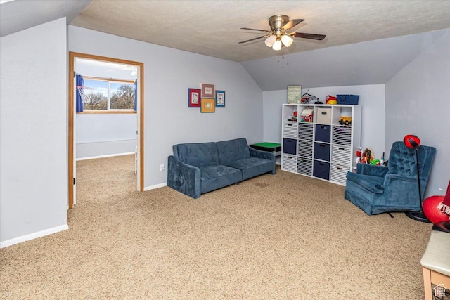 interior space featuring carpet, a textured ceiling, a ceiling fan, lofted ceiling, and baseboards