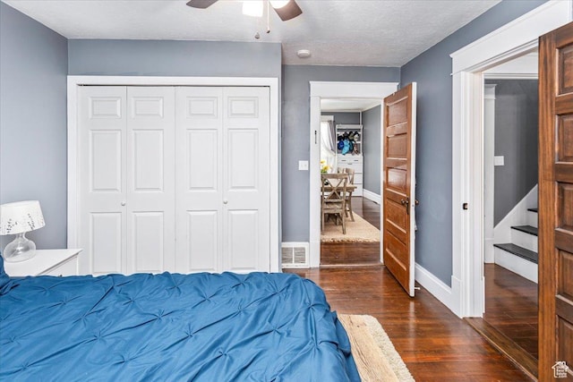 bedroom featuring a closet, baseboards, dark wood finished floors, and visible vents