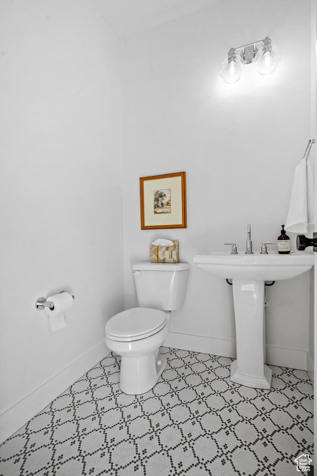 bathroom featuring toilet, tile patterned floors, and baseboards