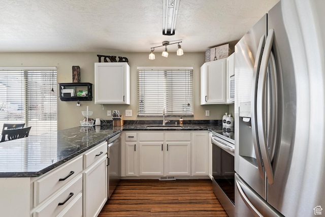 6761 S High Bluff Dr W, West Jordan, UT 84084 - kitchen featuring a peninsula, white cabinetry, dark wood-style flooring, a sink, and stainless steel appliances