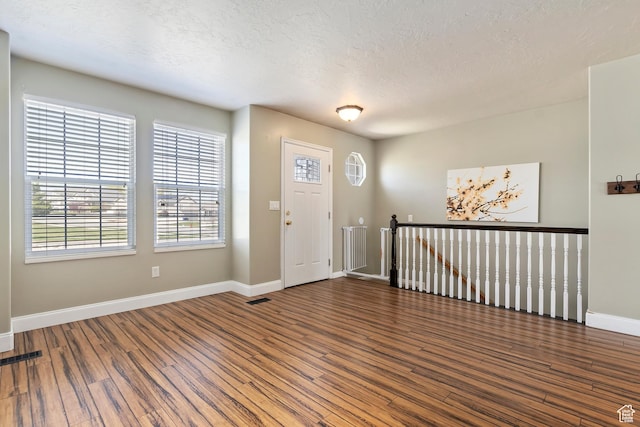 6761 S High Bluff Dr W, West Jordan, UT 84084 - entryway with visible vents, baseboards, a textured ceiling, and wood finished floors