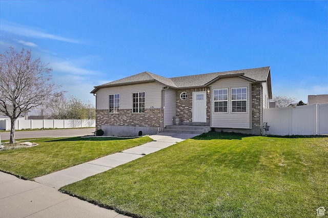 6761 S High Bluff Dr W, West Jordan, UT 84084 - view of front facade with a front yard, brick siding, and fence
