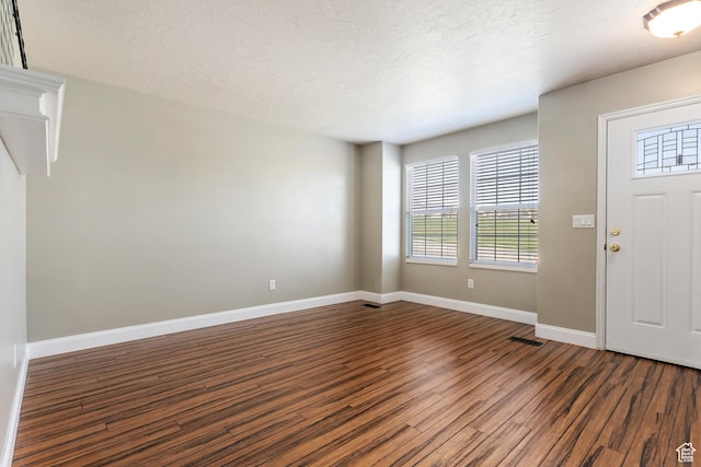 6761 S High Bluff Dr W, West Jordan, UT 84084 - entrance foyer featuring a textured ceiling, wood finished floors, baseboards, and visible vents