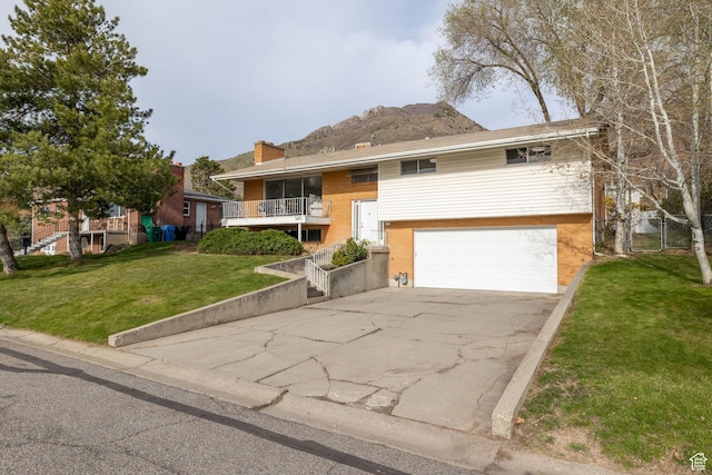 3481 S 3530 E, Salt Lake City, UT 84109 - split foyer home with a front yard, a mountain view, an attached garage, a chimney, and concrete driveway