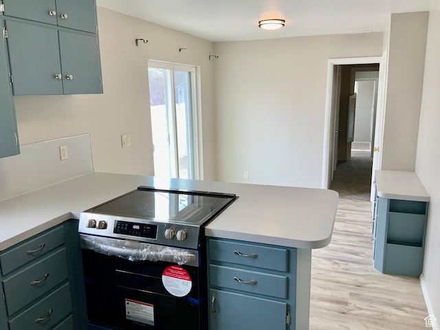 165 W 500 N, Richfield, UT 84701 - kitchen featuring stainless steel range with electric cooktop, a peninsula, light wood-style floors, and light countertops