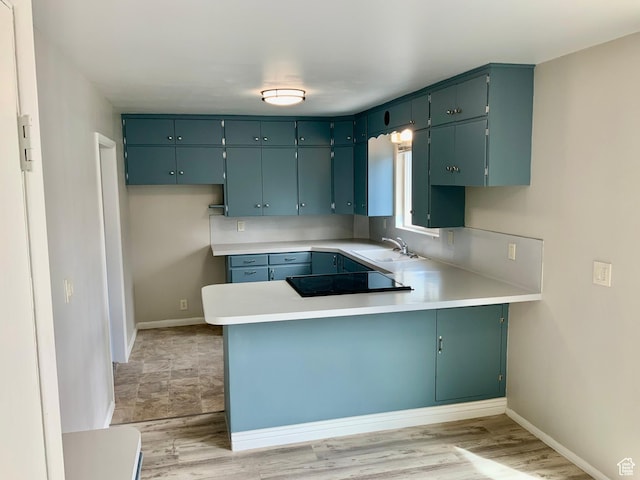 165 W 500 N, Richfield, UT 84701 - kitchen with black electric stovetop, a peninsula, a sink, light countertops, and baseboards